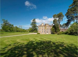 赫里福德Newcourt Manor的草场上一棵树的大房子