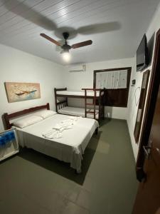 乌巴图巴Pousada Maanaim的一间卧室配有一张床和吊扇