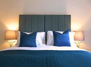 奥赫特拉德Gleneagles Luxury Apartment的一间卧室配有一张带蓝色枕头的大床