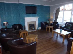 利物浦奥勒尔公园酒店的客厅配有皮革家具和壁炉