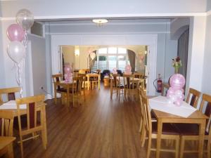 利物浦奥勒尔公园酒店的用餐室配有桌椅和粉红色气球