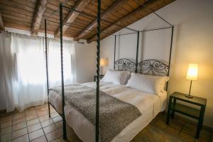 锡拉库扎阿拉朱德卡酒店的一间卧室配有一张带金属天蓬的床