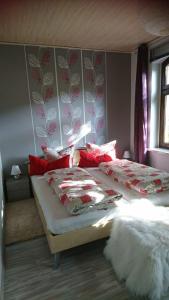克林根塔尔汉希斯公寓的一间卧室配有两张带红白色枕头的床
