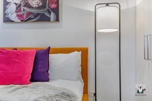 悉尼KOZYGURU WOLLI CREEK KOZY 1 BED APT SYDNEY AIRPORT & SYDNEY CBD NWC020的一间卧室配有带色彩缤纷枕头的床