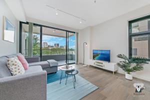 悉尼KOZYGURU WOLLI CREEK KOZY 1 BED APT SYDNEY AIRPORT & SYDNEY CBD NWC020的带沙发和电视的客厅