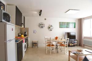 Monchy-Saint-ÉloiSuperbe appartement tout confort "Le Séquoia"的厨房以及带桌子和冰箱的用餐室