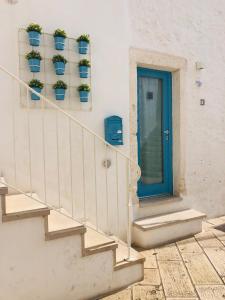 奥斯图尼Dimore del TEMPO PERS0 Mare videre的带有蓝色门和盆栽的楼梯