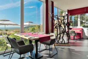 圣马丁Arens Hotel 327mNN的一间带桌椅和窗户的用餐室