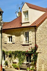 Chassagne-MontrachetPetit Montrachet的一座古老的石头房子,两扇窗户和鲜花