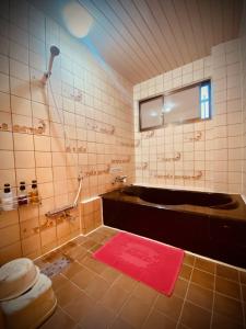 京都嵯峨野酒店（仅限成人）的带浴缸和红色地毯的浴室