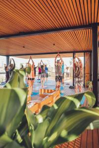 索佩拉纳Moana Eco Surf House的一群人在甲板上做瑜伽