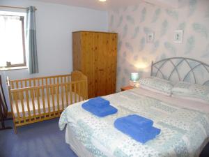 GroeslonCae Berllan Cottages的一间卧室配有一张带2条蓝色毛巾的床