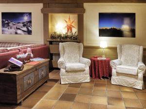 摩德纳迪-坎皮格里奥贝尔泰利酒店的客厅配有两把椅子和一张桌子