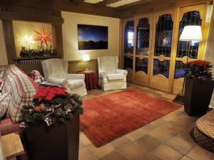 摩德纳迪-坎皮格里奥贝尔泰利酒店的客厅配有两把椅子和红色地毯
