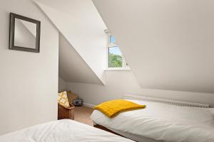 雷丁Chambers Place的阁楼卧室设有两张床和窗户。