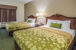 韦瑟福德韦瑟福德伊克诺旅店的酒店客房,配有两张带绿床单的床