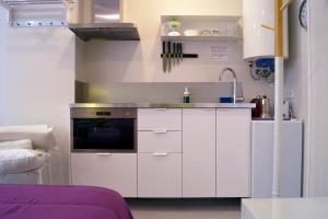 马德里丘埃卡 - 客房公寓酒店的厨房配有白色橱柜和水槽