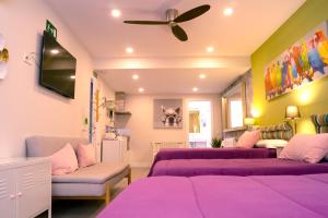马德里丘埃卡 - 客房公寓酒店的客厅配有紫色床和吊扇