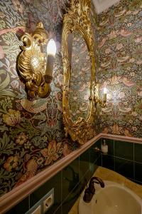 考纳斯Inner Blossom的浴室设有金色镜子和水槽
