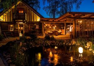 文迪施里茨SATAMA Sauna Resort & SPA的小木屋前面设有池塘