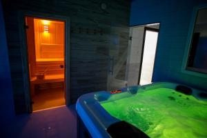姆拉哥沃Hotel Rezydencja Mazury SPA & Lake的浴室设有装满绿色液体的浴缸