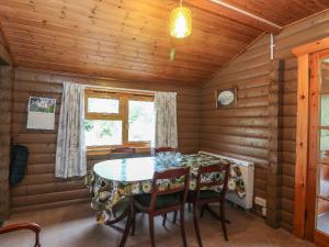 基林Millmore Cabin的小木屋内的用餐室,配有桌椅