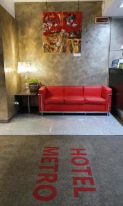米兰梅特罗酒店的红色的沙发,在地板上有一个标志