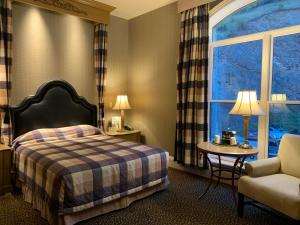 戴德伍德Celebrity Hotel的酒店的客房 - 带一张床、椅子和窗户