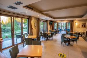 普拉曼塔阿纳瓦斯山度假酒店的餐厅设有木桌、椅子和窗户。