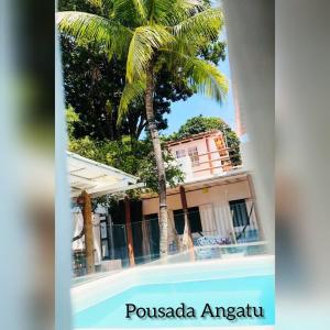阿拉亚尔达茹达Pousada Angatu Arraial - Rua do mucugê的一座建筑前的棕榈树