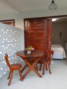 圣米格尔-杜斯米拉格里斯Pousada Paraíso dos Milagres的一张木桌和两张椅子,位于一个配有床的房间
