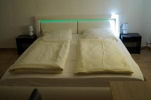 兰格尔斯海姆拉丰塔纳酒店的一张带白色床单和枕头的床