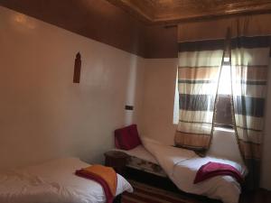 Aït ZiriMaison D'hôtes Dar Afra的小房间设有两张床和窗户
