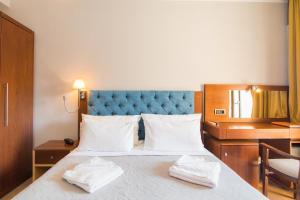 古维亚OPERA BLUE Hotel Gouvia Corfu的一间卧室配有一张床,上面有两条毛巾