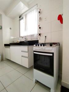 里约达欧特拉斯MAR & SOL Apartamentos I - Free Wi-Fi的白色的厨房配有炉灶和窗户。