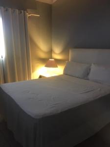 蓬塔卡纳Hotel Maracas Punta Cana的卧室配有白色的床和灯