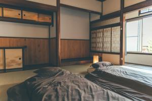 舞鹤市ゲストハウス 宰嘉庵 かなで GuestHouse Saikaan KANADE的客房设有两张床和窗户。