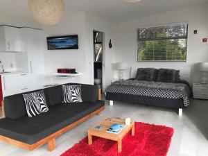 欧尼坦基Sea La Vie - Waiheke Island Luxury Accommodation的客厅配有黑色沙发和桌子