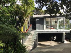 欧尼坦基Sea La Vie - Waiheke Island Luxury Accommodation的一座房子,有楼梯通往房子的前面