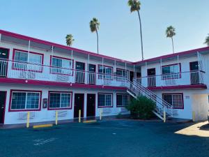 洛杉矶Casa Valentine Inn - Los Angeles的一座红色和白色的建筑,设有停车场