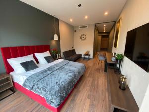 拉多姆Aparts Hotel Radom的一间卧室配有一张大床和红色床头板