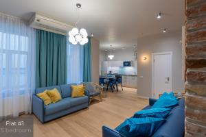 里加Dandelion Apartments Brīvības的一间带2张蓝色沙发的客厅和一间厨房
