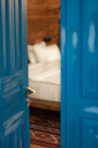 SazanoEthno Sazano Hotel的开放式蓝色门,后面设有一张床