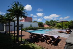 大里贝拉Quinta dos Peixes Falantes的一个带椅子的游泳池,并种植了棕榈树