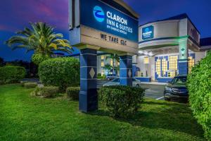 克利尔沃特Clarion Inn & Suites Central Clearwater Beach的门前有停车场的酒店标志