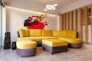 雅典STAY INN的客厅配有黄色沙发和绘画作品