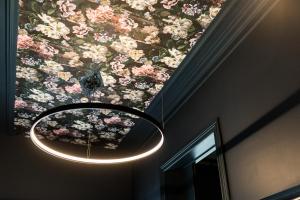 普罗丰德维耶Hôtel Vedette的吊灯挂在天花板上,挂着鲜花