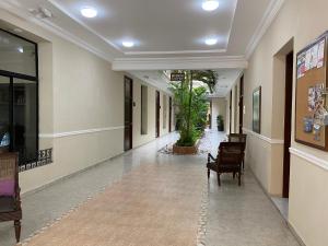 坎佩切坎佩切洛佩斯酒店的大楼里带椅子的空走廊