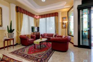 利多迪耶索罗加尔尼圣卡罗酒店的客厅配有红色皮革家具和电视