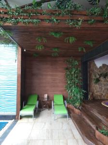 叶森图基Estet Hotel的庭院配有两把绿色椅子和一张桌子